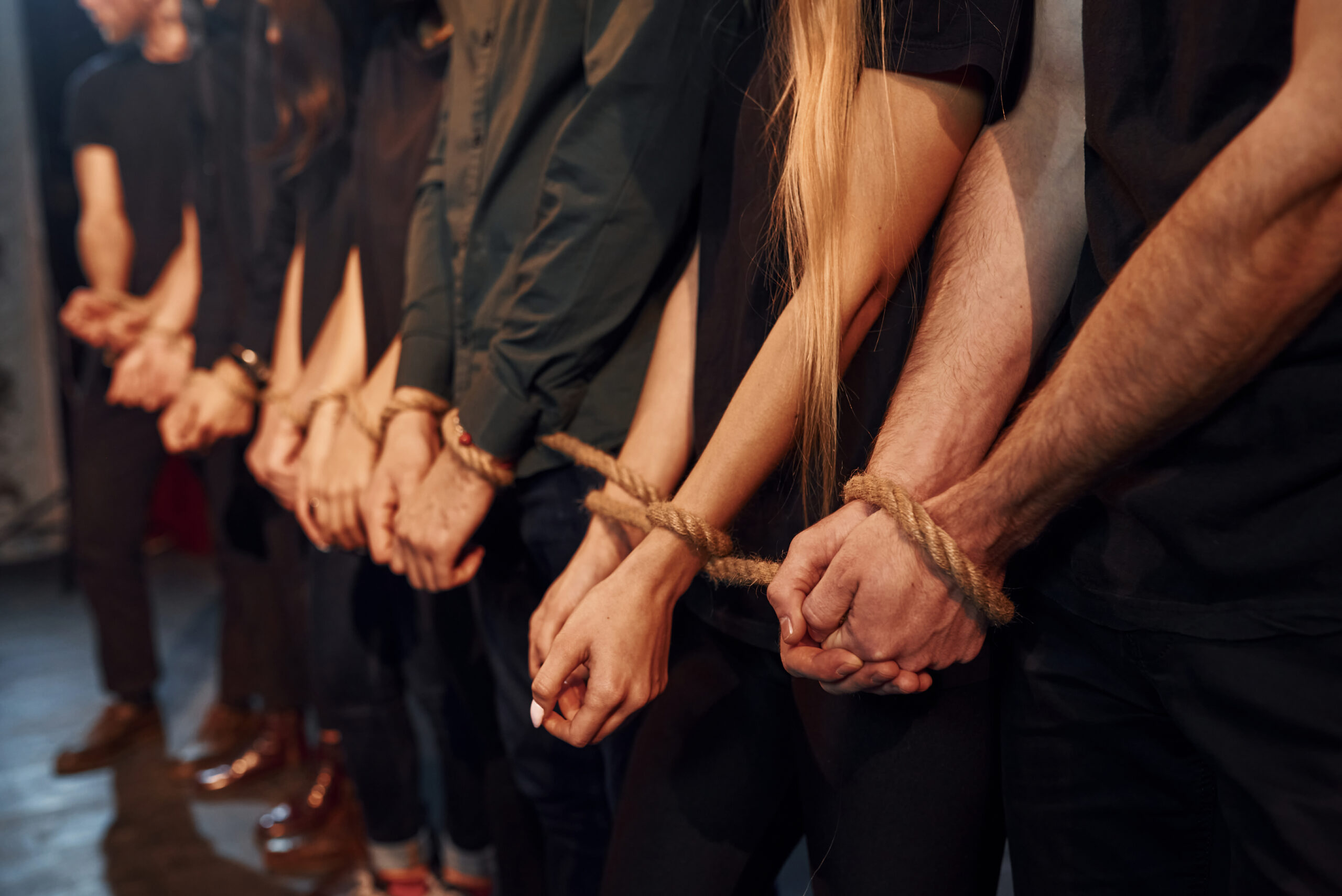 Knot in the hands. Group of actors in dark colored clothes on rehearsal in the theater.